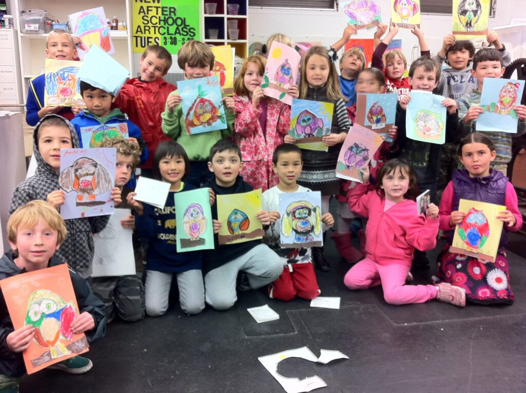 A group of children showing their finished paintings