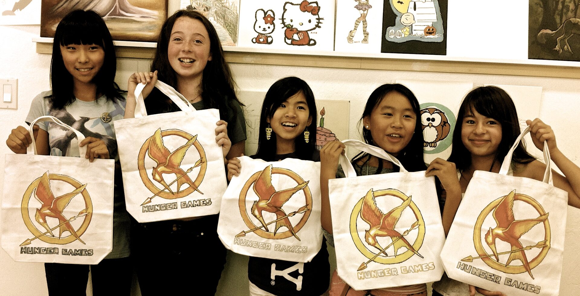 Five children showing customized tote bags