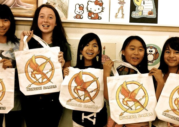 Five children showing white personalized tote bags