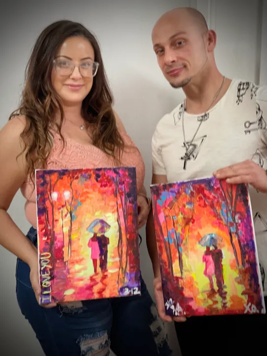 A couple holding the same painting frames