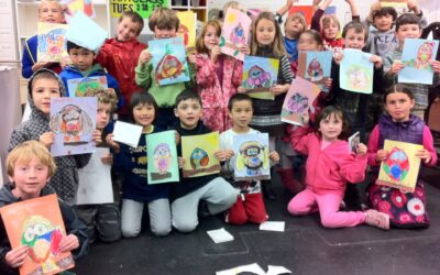 A group of children showing their finished paintings